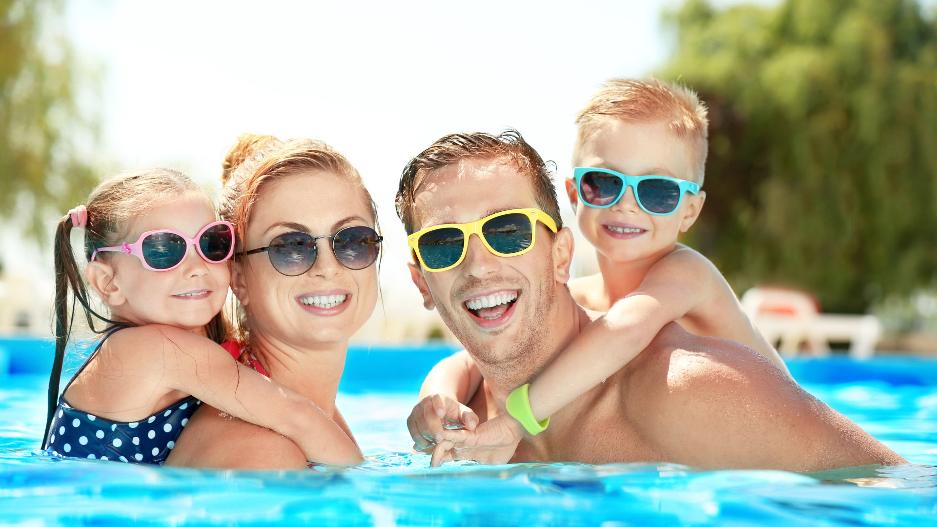 mom, dad and two kids together in pool